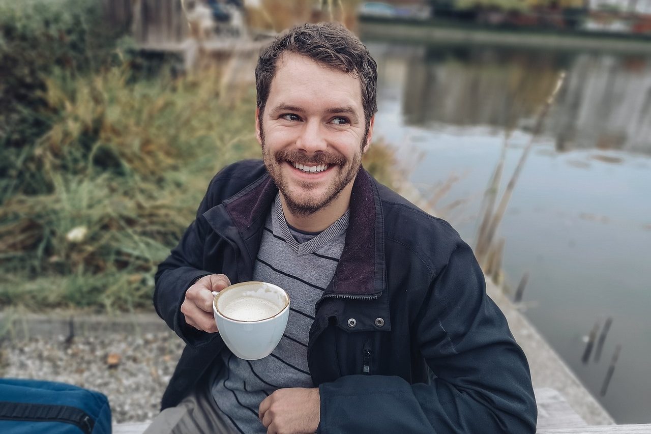 Lächelnder Mann mit Tasse im Freien